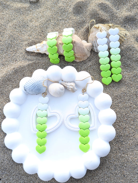 Handmade set of  polymer clay earrings featuring a line of hearts in a white to lime green gradient