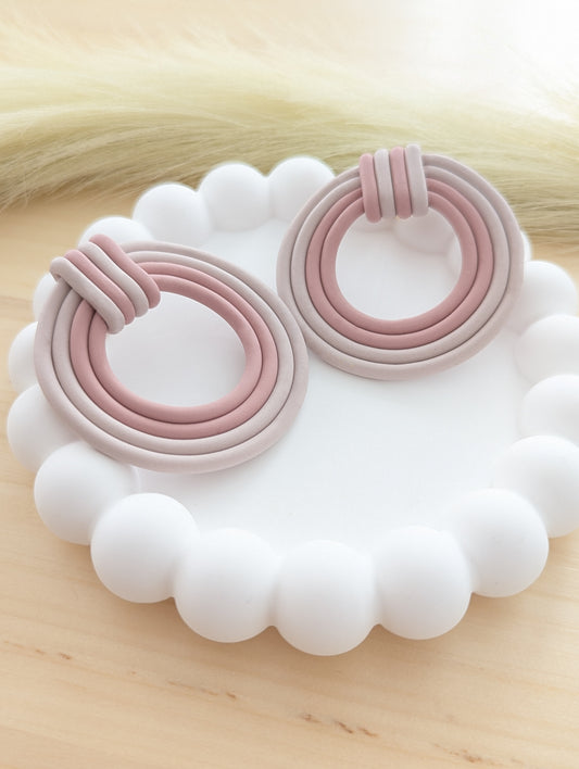 Handmade polymer clay earrings in soft pink and neutral tones, displayed on a white scalloped tray for a minimal and elegant look.